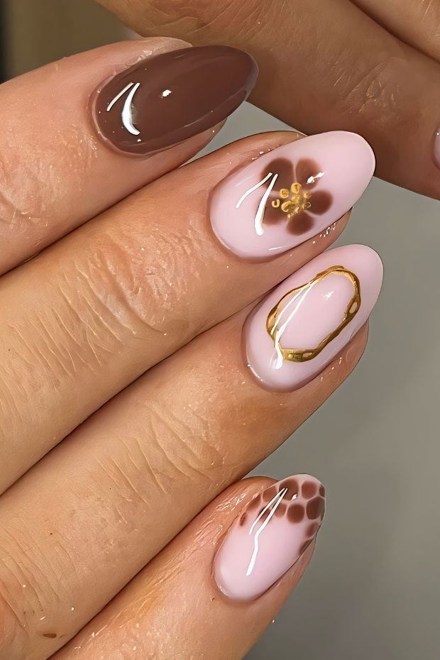 Elegant brown and pink nail design featuring floral patterns and gold accents for a chic nail art look.