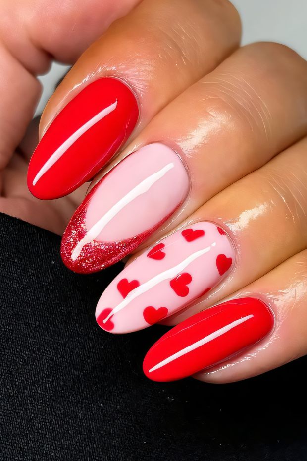 Vibrant red nails with heart accents and glittery pink tips, perfect for romantic occasions.