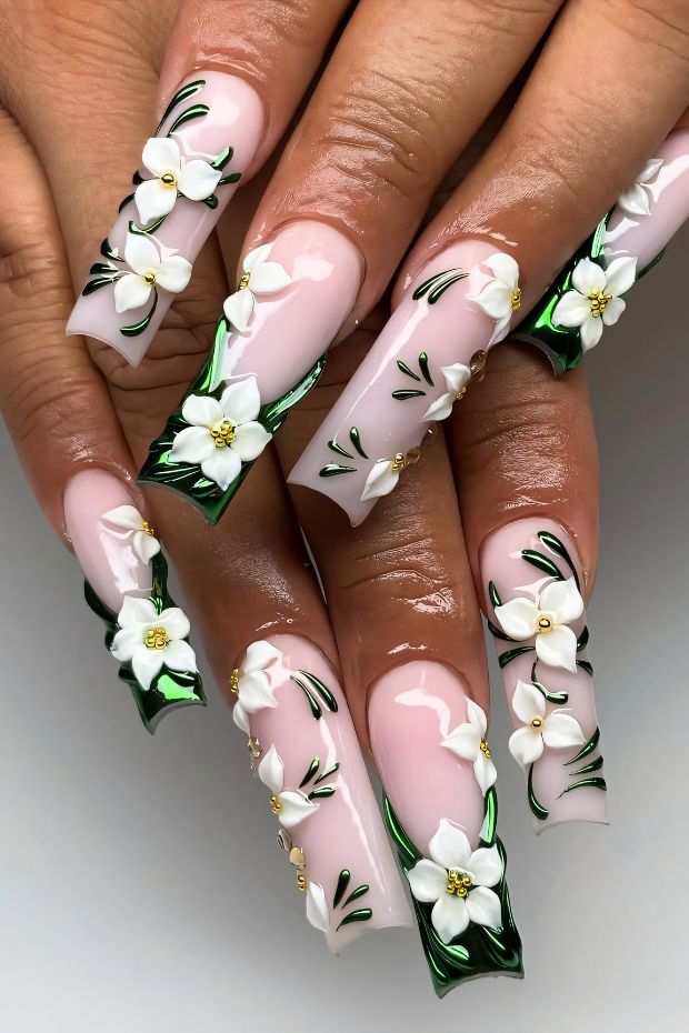 Birthday nails with pink base, white floral designs, and green accents, perfect for elegant celebrations.