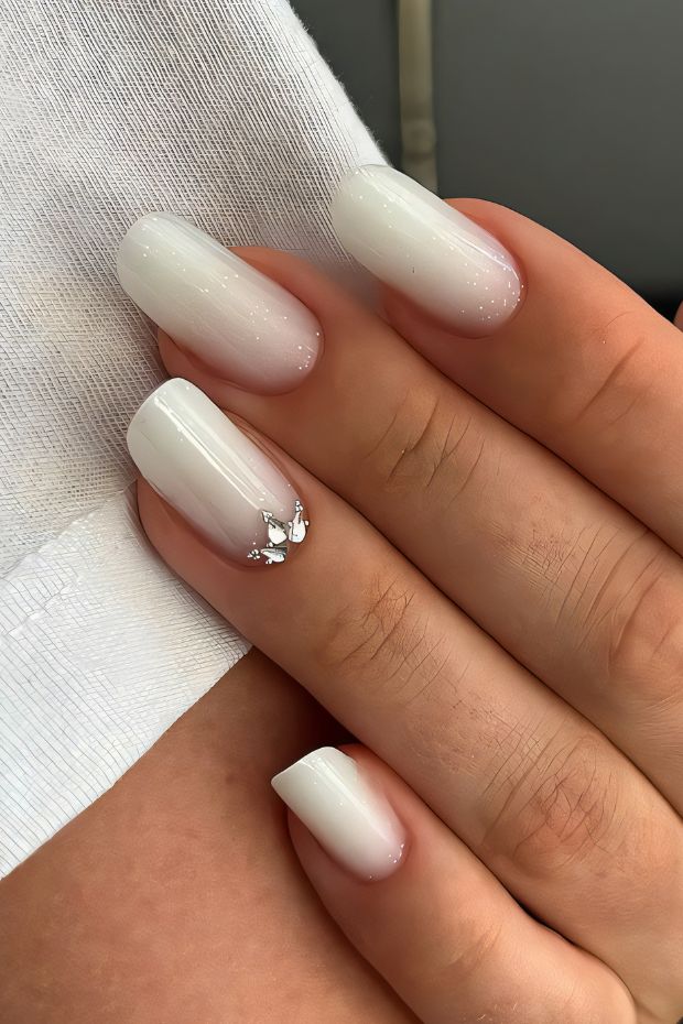 Elegant white ombre nails with silver accents, perfect for modern nail art enthusiasts seeking chic designs.