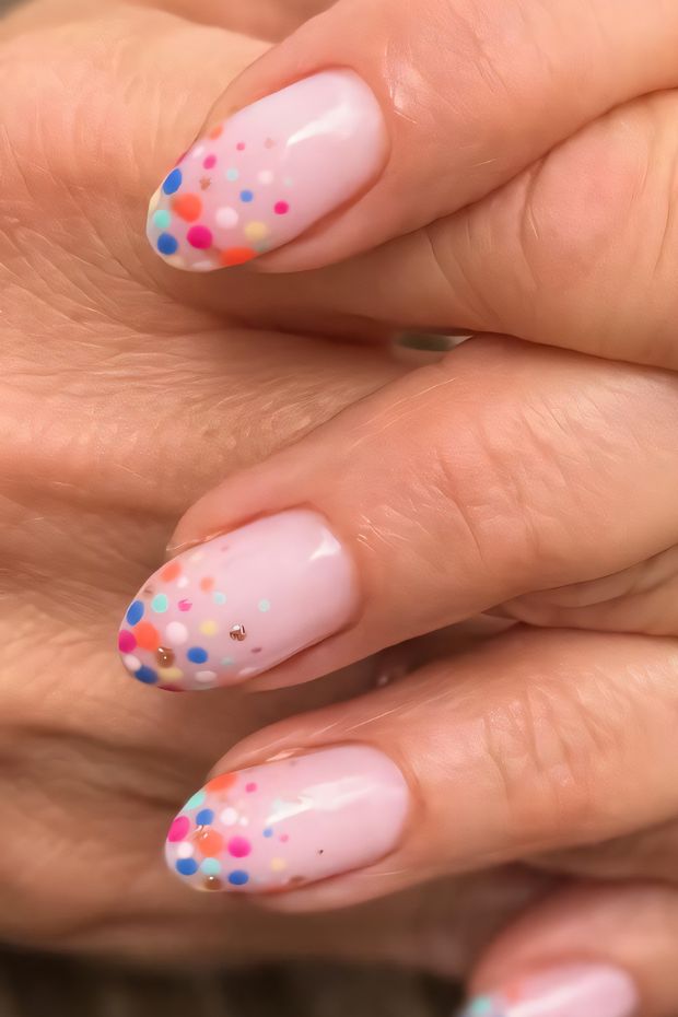 Festive birthday nails with pink base and colorful confetti dots, perfect for celebrating special occasions.