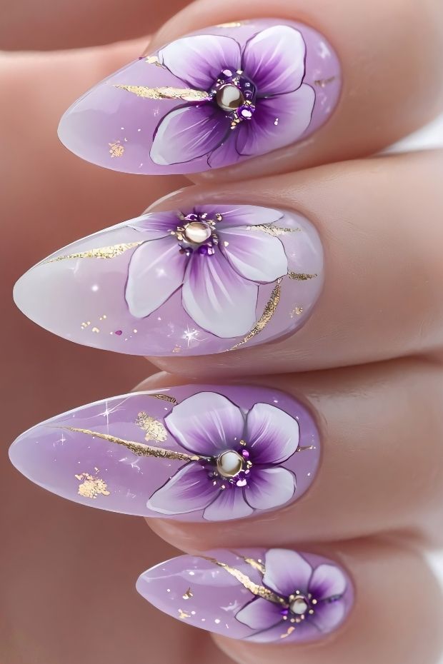 32 Creative Acrylic Nail Ideas You’ll Want to Try This Season 27 Elegant floral acrylic nails in purple and gold featuring delicate flower designs and sparkling accents.