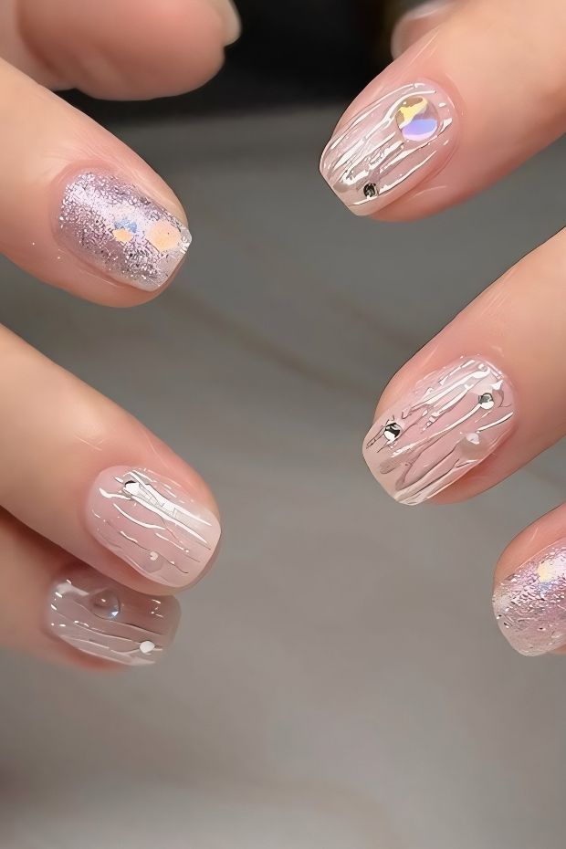 32 Creative Acrylic Nail Ideas You’ll Want to Try This Season 18 Nail design featuring sheer nude and silver glitter with decorative stripes and rhinestones for an elegant finish.