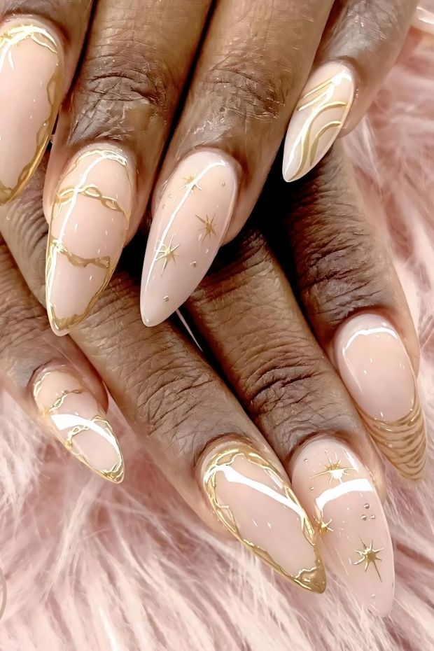 32 Creative Acrylic Nail Ideas You’ll Want to Try This Season 16 Nude acrylic nails with gold accents and star designs for an elegant nail art idea.