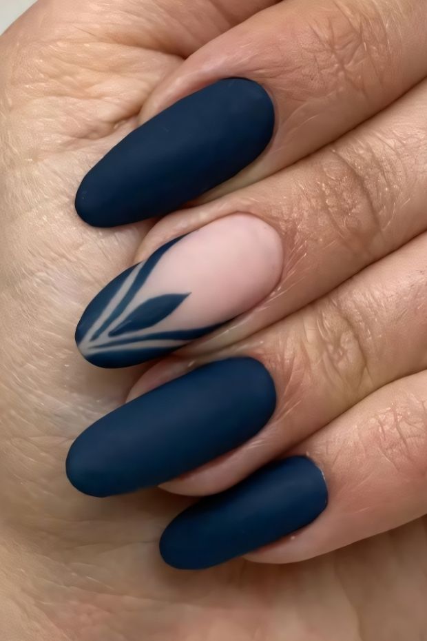 Matte navy nail design with floral accents featuring a pastel pink accent nail.