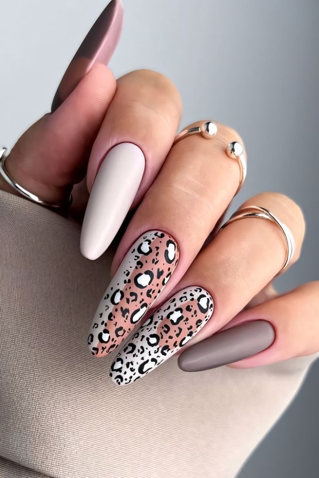 Matte nail design with playful leopard patterns in soft pink and muted tones, perfect for stylish manicures.