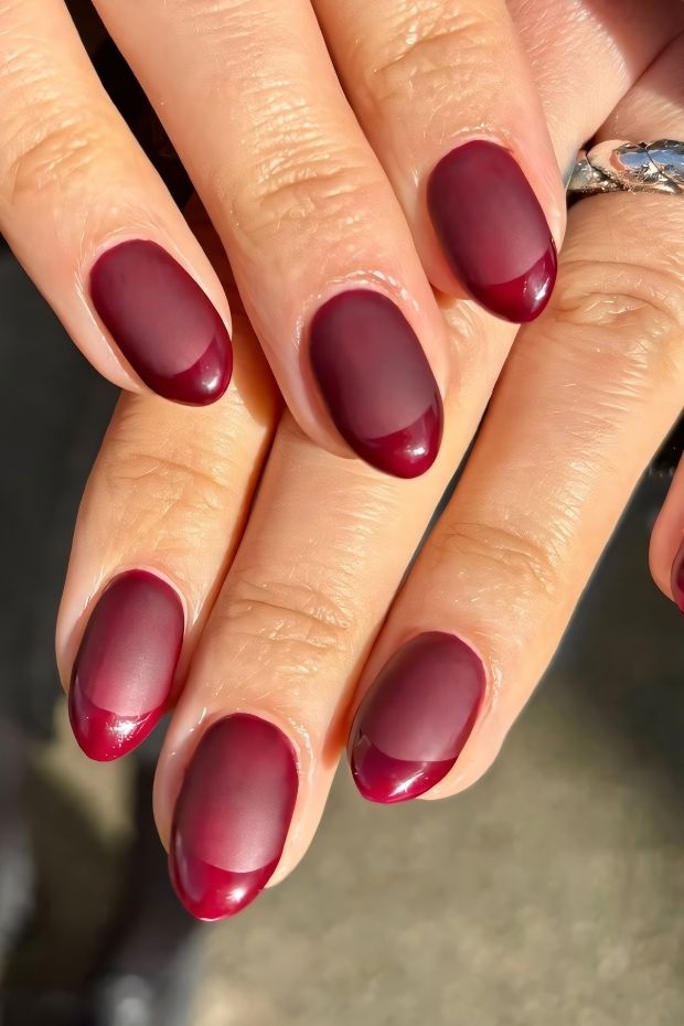 Matte burgundy nails with a French tip design, showcasing a sophisticated and elegant nail art style.