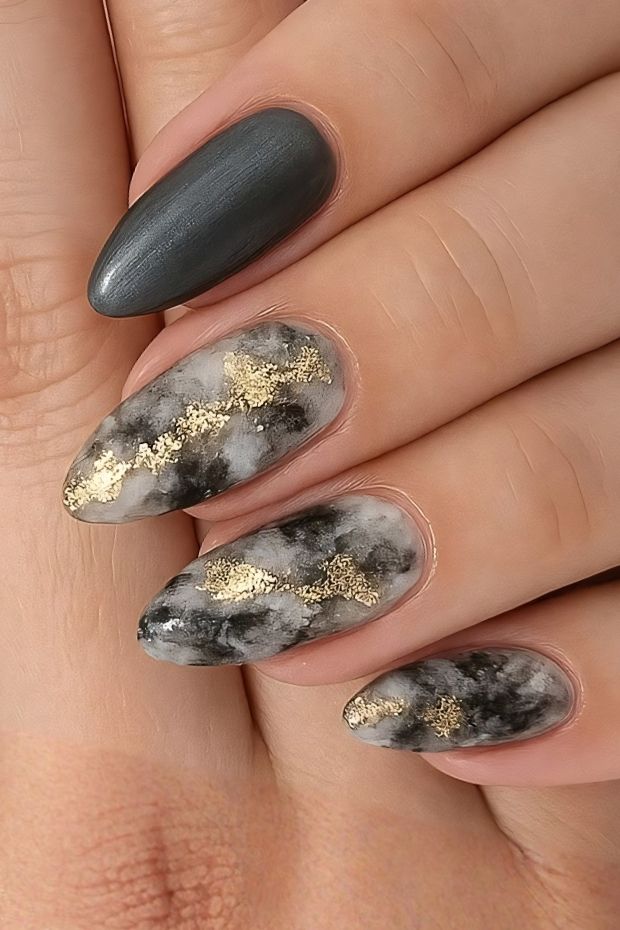 Matte marble nail design in black and gray with gold accents for elegant nail art inspiration.