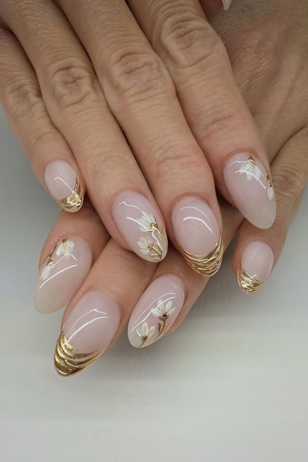 32 Creative Acrylic Nail Ideas You’ll Want to Try This Season 19 Elegant acrylic nails with gold tips and floral designs, featuring a nude base for a chic finish.