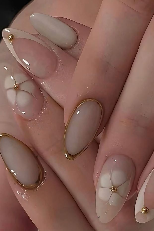 32 Creative Acrylic Nail Ideas You’ll Want to Try This Season 3 Acrylic nails with floral designs and gold accents in a stylish arrangement, showcasing elegance and contemporary nail art ideas.