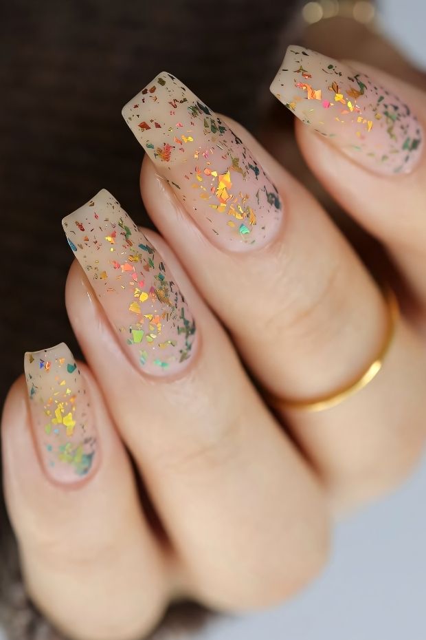 Matte nude nails with colorful flakes, perfect for a trendy nail art design.
