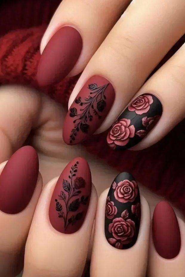 Matte burgundy nail art featuring intricate floral designs and patterns for a sophisticated look.