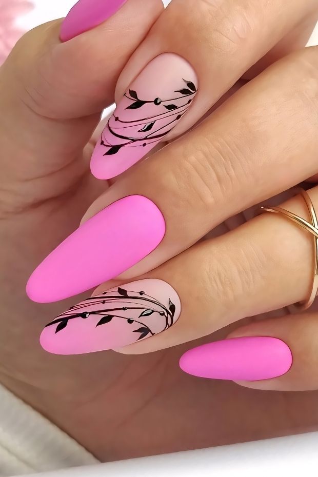 Matte pink nails with floral designs and elegant details for a trendy nail art look.