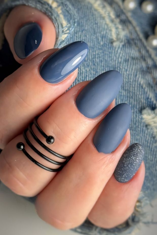 Matte blue almond-shaped nails with a glittery accent nail for a modern and stylish look.
