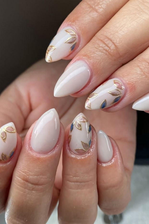 32 Creative Acrylic Nail Ideas You’ll Want to Try This Season 17 Elegant acrylic nails with gold and blue leaf designs on a nude base for a stylish manicure.